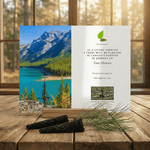 Memorial card with a scenic view of Alberta lake and mountains, placed on a wooden surface.