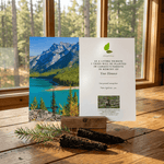 Memorial card with scenic photo of mountains and lake on a wooden surface.