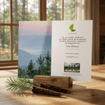 Card with scenic design and text on a wooden surface with a window in the background
