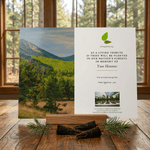 Card with nature-themed design and text on a wooden surface with a window view.