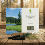 Memorial card with tree planting message on a wooden surface with a scenic background