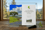 Memorial plaque with landscape design on a wooden surface with a window in the background.
